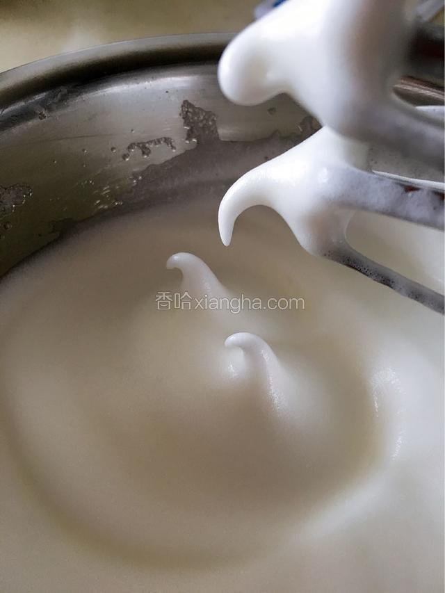三次糖加完后，边打边观察蛋白的状态。这个地方是和戚风区别最大的地方。轻芝士蛋糕需要将蛋白打发到湿性状态。即当停止打蛋器并缓慢的将打蛋器提起，蛋白会拉出带有弯钩的小山，打蛋器上留下带有弯钩的三角形时的蛋白状态。