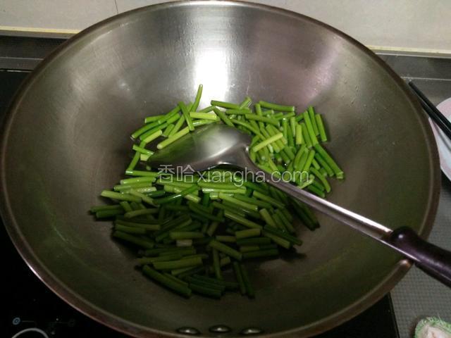 热锅下油，下蒜苔炒熟