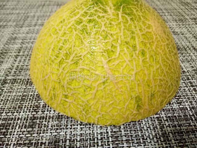把冷藏过的哈密瓜取出，切出顶部的一块。