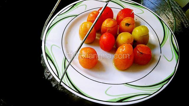 水沸腾就用万能夹把圣女果的盘子夹紧放入沸水锅里的蒸架上面。