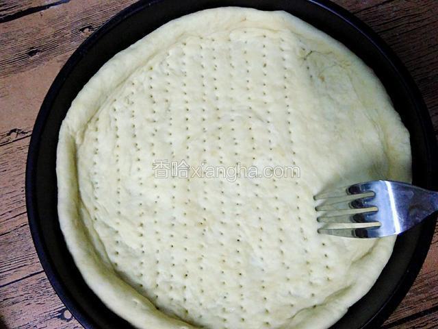 用小叉子均匀的在饼胚上戳些小洞。