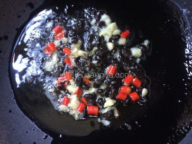 将锅洗净，倒入适量的食用油，将之前准备好的蒜蓉，豆豉和小米椒倒入锅中，小火炒香