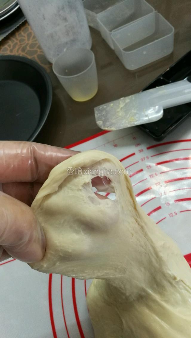 加入黄油和盐之后，开3档继续搅拌，面团组织会重新解体再收拢，记得用硅胶刮刀，把桶壁上的黄油刮下帮助沾到面团上。
搅拌差不多5-6分钟的时候，检视下面团，这时候面团扩展的更薄但是裂口还很粗糙，再多搅2·3分钟，一边观察不要过头了把面筋打断就不好了。