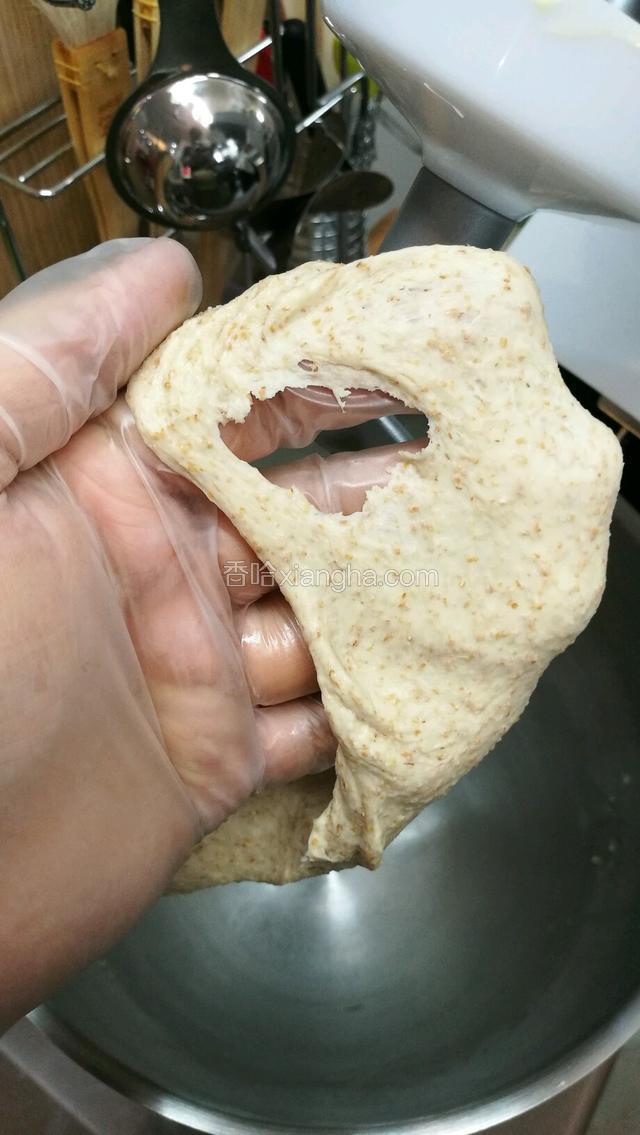 能拉出厚膜之后才可以投入盐和黄油，盐起到洁白面团和支撑骨架的作用，黄油是帮助面团进一步扩展和不粘手，加入黄油和盐之后，开3档继续搅拌。
搅拌差不多5-6分钟的时候，检视下面团，这时候面团扩展的更薄但是裂口还很粗糙，再多搅2·3分钟，一边观察不要过头了把面筋打断就不好了。
