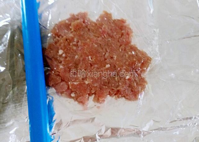 取适量的肉摊在锡纸上，再盖上一层保鲜膜