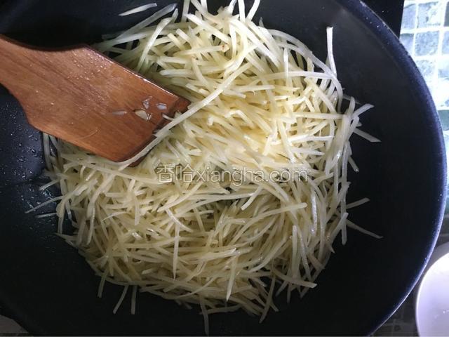 然后加入土豆丝一起翻炒，滴两滴醋炒