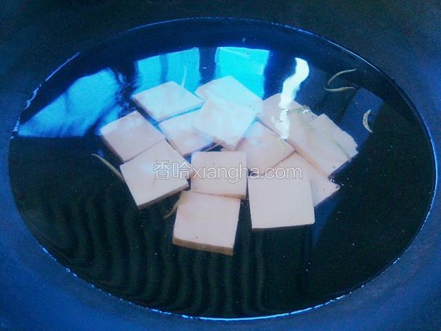 水开后把豆腐放入锅里煮。