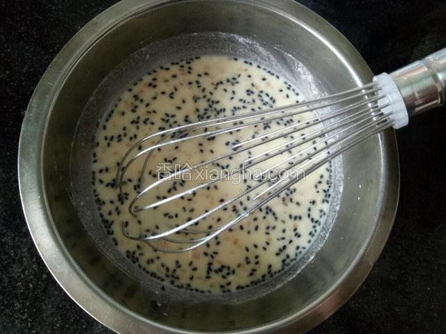 面粉、玉米面和芝麻混合一起，搅拌成粉浆。