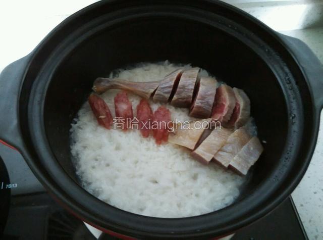 饭煮得差不多干水时，将腊味放入，一起闷煮