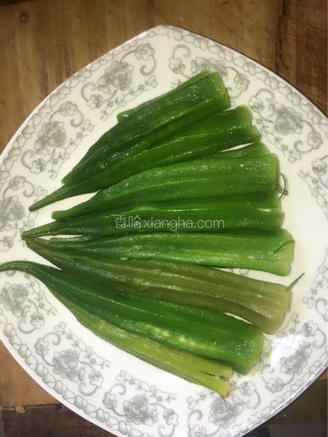 秋葵焯熟捞出后，淋干水分，去其蒂，对半切开，这样比较容易入味。