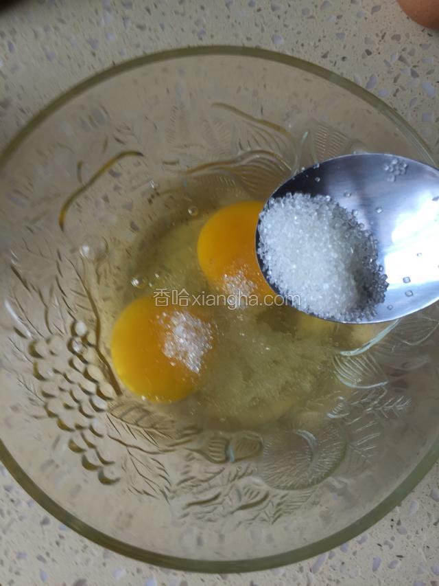 鸡蛋打入玻璃碗中，加入白砂糖，用手动打蛋器搅打均匀起泡