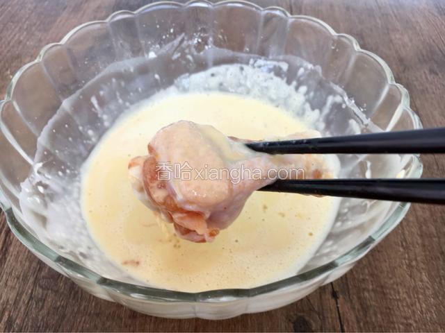 将腌制好的鸡腿沾满蛋液。
