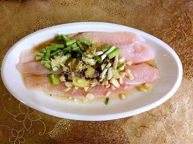 将葱姜蒜倒入鱼盘中，按自己的口味加盐、胡椒粉、淀粉、料酒和鸡精，用手抓拌均匀