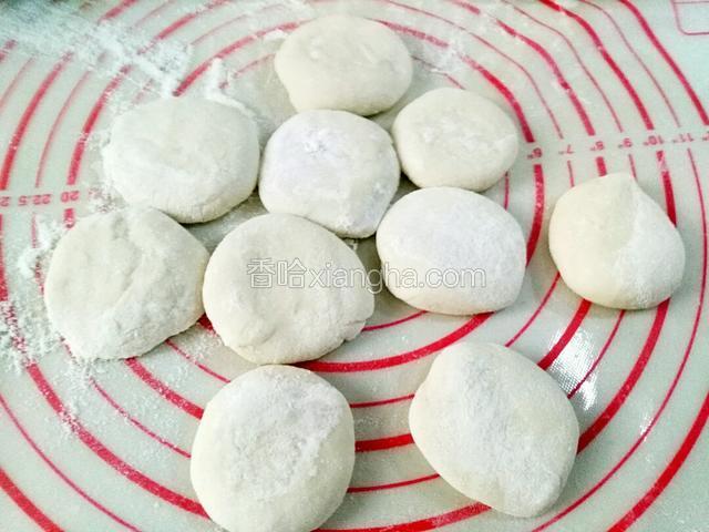 把每个剂子都按扁了备用。用擀面杖也行，擀的边上薄中间厚，
