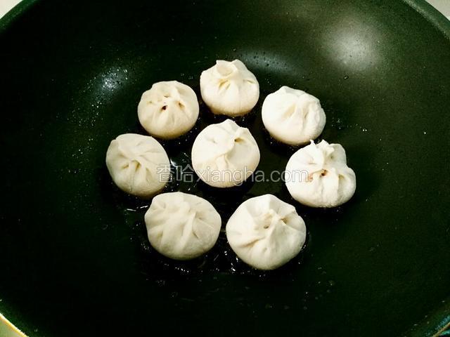 准备热锅，倒少量食用油，油热摆放上小包子。像图这样。