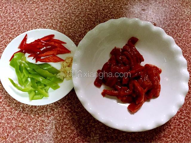 牛肉切成条状，红辣椒、青辣椒切条状，蒜切碎备用