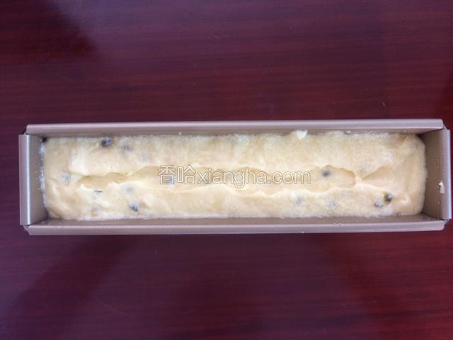 翻拌好的面糊装入模具中，中间用刮刀处理出一条裂缝，这样拷出来的磅蛋糕会有漂亮的裂痕哦！