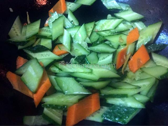 热锅冷油，油热加入葱花炒香，加入黄瓜胡萝卜，淋入酱油翻炒至八成熟


