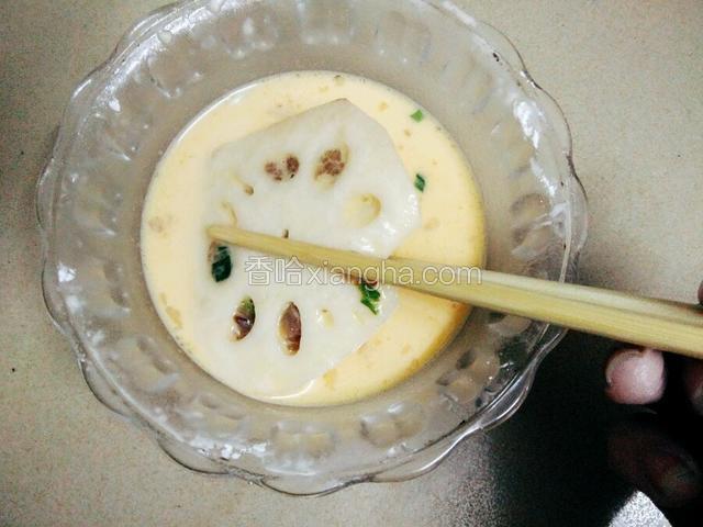 莲藕夹放入拌好的鸡蛋生粉糊里，让莲藕挂上生粉糊。