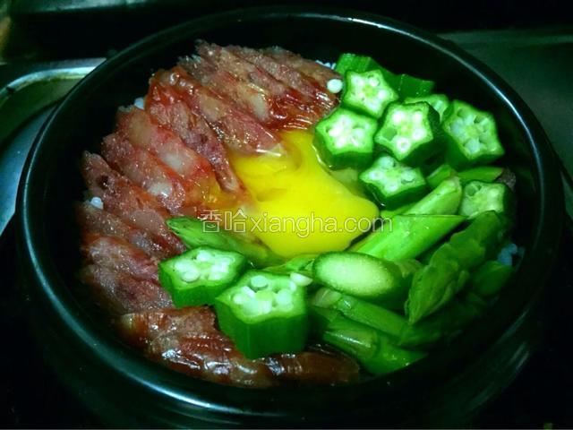加入芦笋段和秋葵厚片，米饭用勺子按压一个坑打入一个鸡蛋盖好盖子，小火煮五分钟鸡蛋定型即可。
