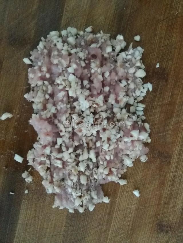 香菇切丁，肉切碎末，切少许姜末，撒些许精盐，一起均匀剁碎备用。