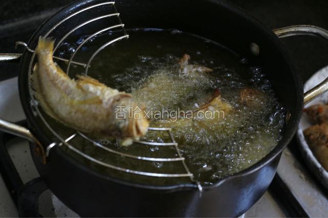 火上放油炸锅，加多些油烧至6成热，将小黄花鱼放入其中煎炸至焦黄。也可用平底锅煎至黄身两面变黄。