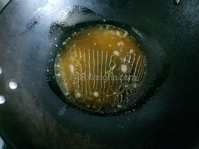 另换一个炒锅，将炸完鱼的油慢慢倒入新的锅内，因为刚才炸完鱼的锅里面沉淀的有面粉，现在只取表面的油