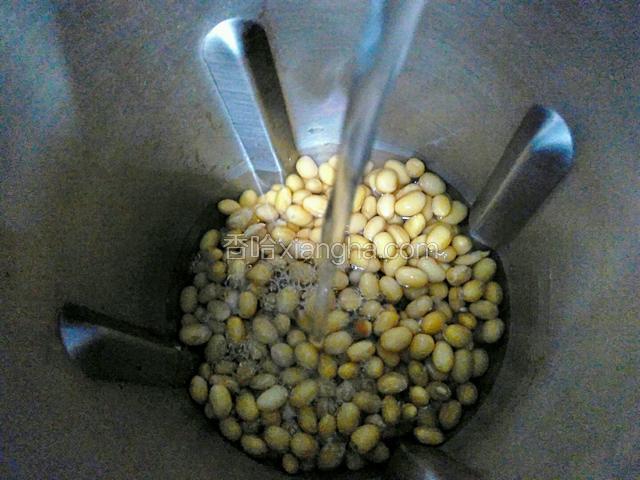将泡好的黄豆和大米放入豆浆机，加1200ML清水打成豆浆。