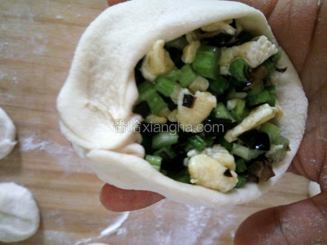 把馅放中间，用右手母指和食指来捏包子的边缘，捏出褶来