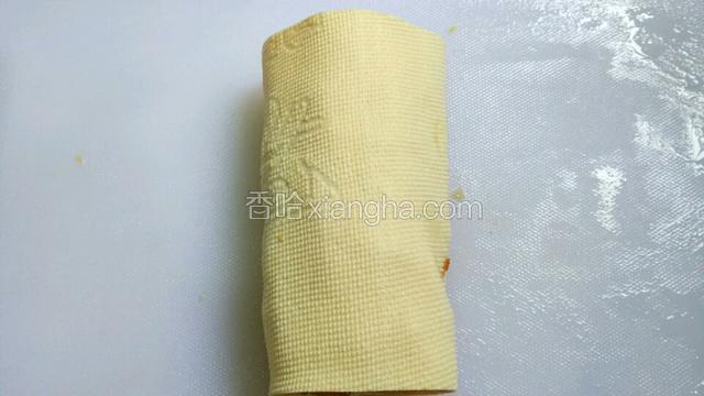 再将豆皮向一端卷起来。