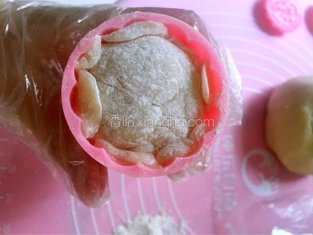 月饼模具中加入适量的熟糯米粉，然后把冰皮团放入