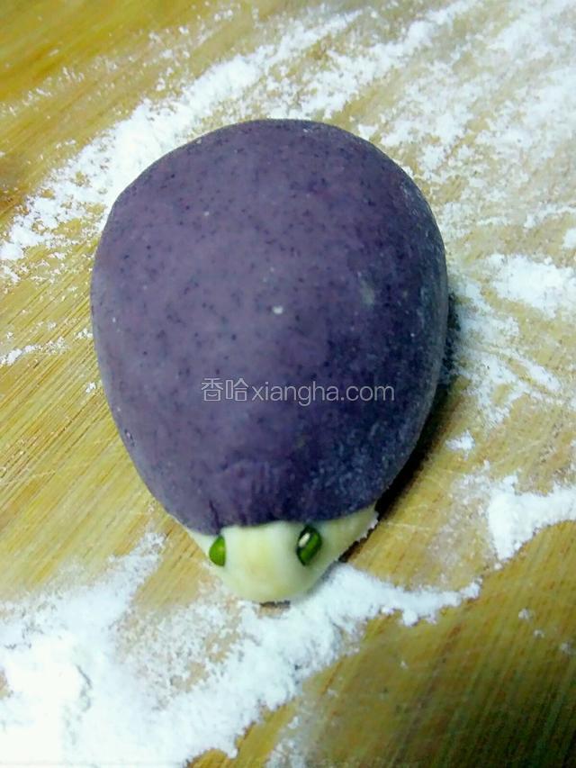 反过来，把豆包陷儿放入面片的中间包成圆锥形，白色部分为椎尖儿做刺猬的嘴，两侧放上绿豆做眼睛
