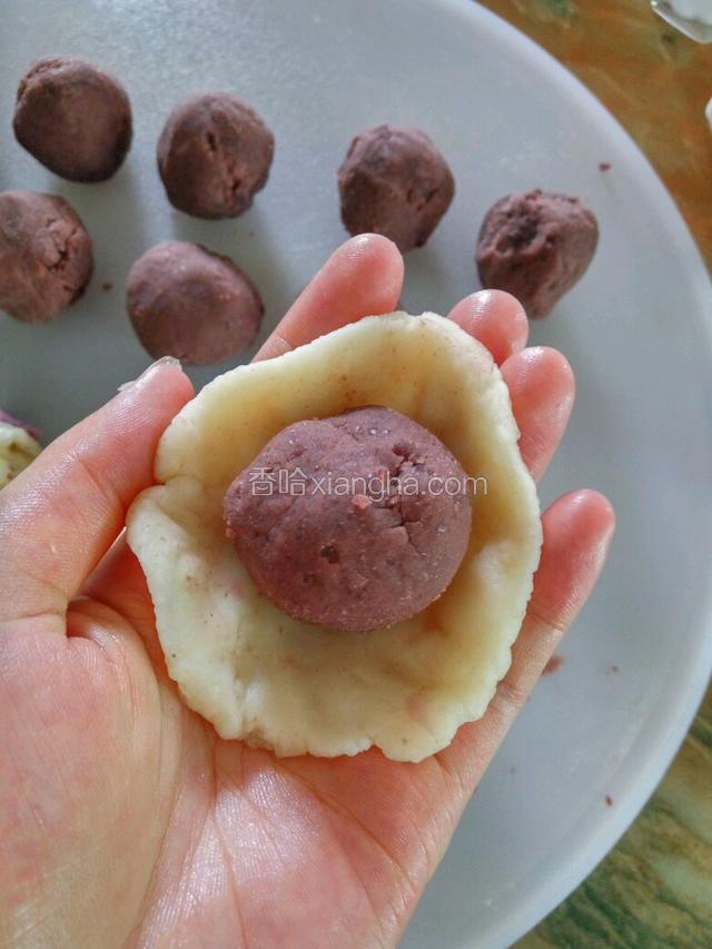 紫薯面团粘在白面团上压开，紫薯面朝下，包入豆沙