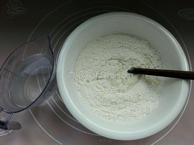 面粉放入干净盆中，把温水备上，手敢温度就行，用筷子和成面团。