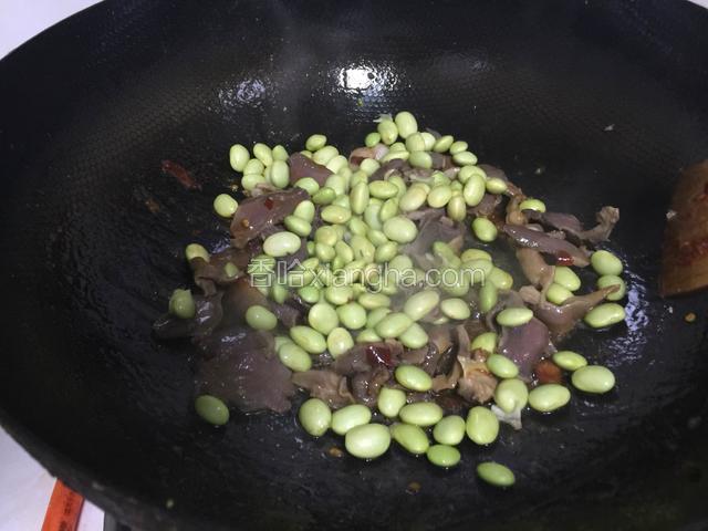 鸡杂炒出水分之后加入毛豆.翻炒至毛豆也变色加入醋