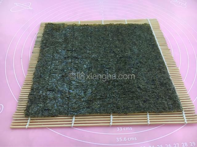 寿司帘洗净擦干
放在干净的砧板上
紫菜光滑面向下粗糙面向上放在寿司帘上