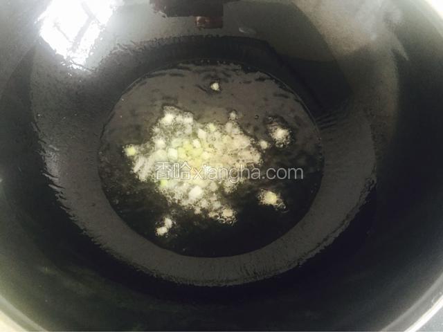 茄子浸泡好后控干水分，炒锅烧热放油，把葱姜蒜炒香
