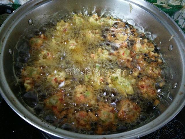 用一个圆头的勺子一个个挖进油里炸制。