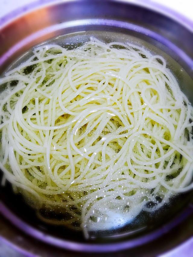 盆中倒入凉白开水，面条捞出放入盆中过水。