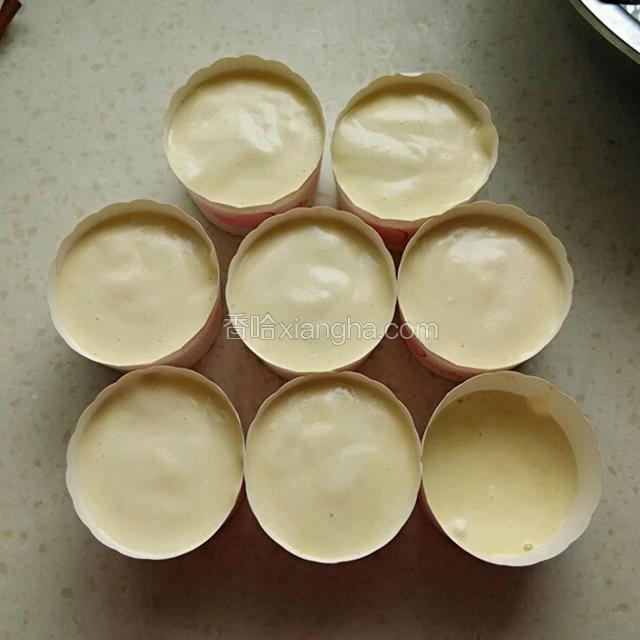 所有的面糊装入纸杯中，轻轻的在台面上震一下，震出里面的大气泡。