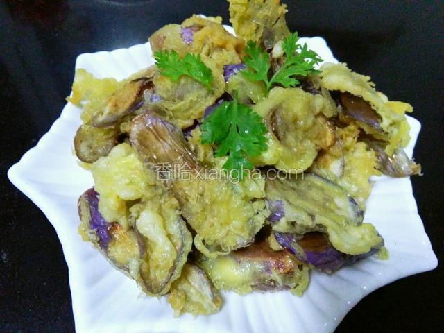 将酥炸茄子装盘，用香菜叶点缀
