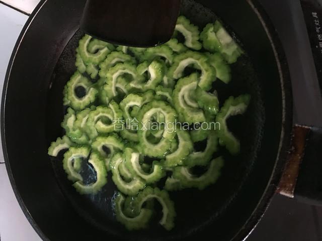 半锅水烧开下苦瓜焯水，下少许盐去苦味，烧至断生捞出冲冷水备用