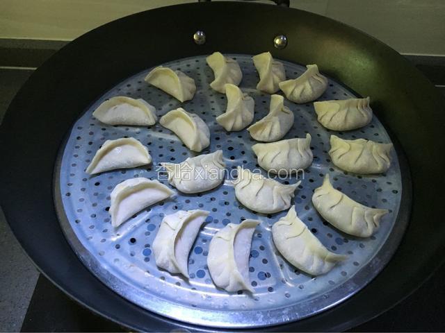 取一蒸锅，下面加入适量清水，把饺子放入锅中，每一个饺子四周留一点余地。