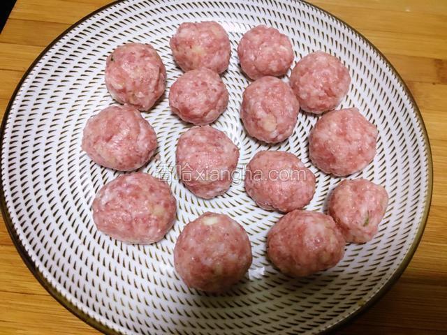用手将肉糜搓成肉丸放入盘中待用