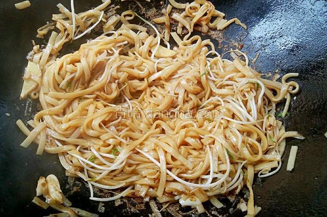 放入豆芽和河粉翻炒，加适量食盐，生抽，老抽调味。