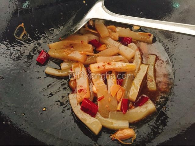 炒散之后倒入切好的魔芋条，大火炒三分钟。