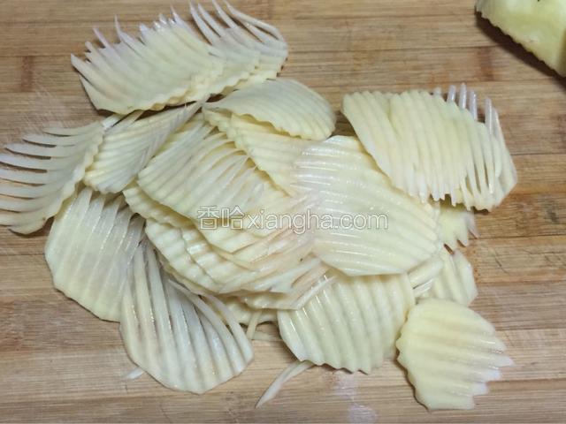 把土豆切片，现切现用，要不然会变黑，如果泡过水就不容易炸脆了，土豆片厚薄尽量切均匀。