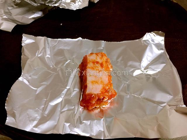 锡纸裁剪成一定大小，把腌好的排骨一根一根包好，两头拧紧。