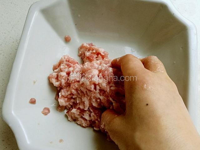 加入后用手不停的从底部铲起，直至肉吸收了蛋汁，放置备用。