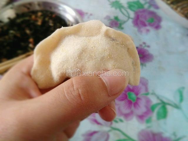 把馅放进饺子皮里包上，边缘捏好。